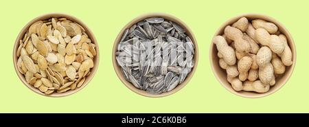 Three types of snacks in brown bowl: Sunflower seeds, peanuts in shell, salty pumpkin seeds. Top view of different food samples Stock Photo