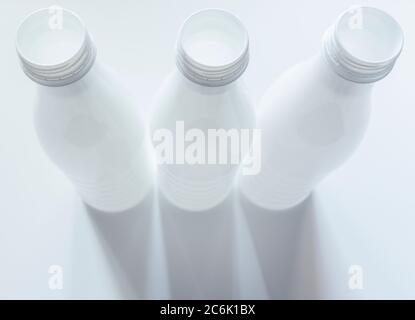 Open empty white plastic milk bottles on White background Stock Photo