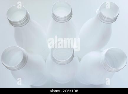 Open empty white plastic milk bottles on White background Stock Photo