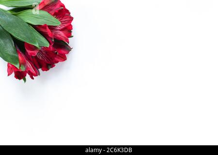 Bouquet of red flowers alstroemeria on white background. Flat lay. Horizontal. Mockup with copy space for greeting card, social media, flower delivery Stock Photo