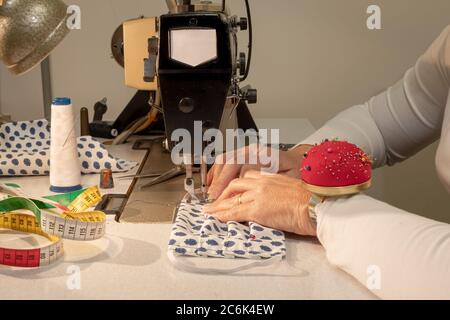 Manufacture of washable face masks for face protection against Covid-19 virus, coronavirus, allergy, epidemic and global pandemic. Stock Photo