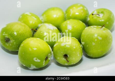 Washing fruit. Soapy green apples in the sink.  Stock Photo