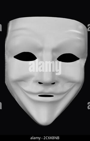 Anonymous white mask isolated on a black background. Stock Photo