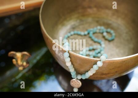 Tibetan singing bowl close up with beautiful turquoise Mala for soundhealing