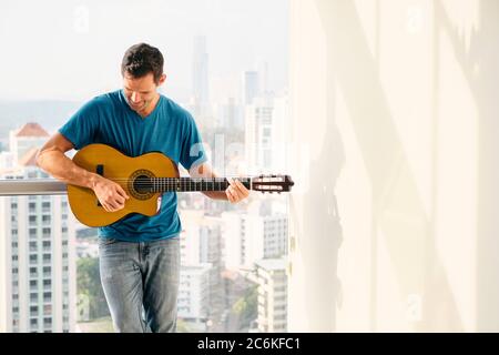 Portrait Of Adult Man Playing Classic Guitar And Singing Stock Photo