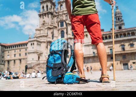 Tired Legs Close up photo of Young backpacker man pilgrim standing on the Obradeiro square (plaza) - the main square in Santiago de Compostela as a en Stock Photo