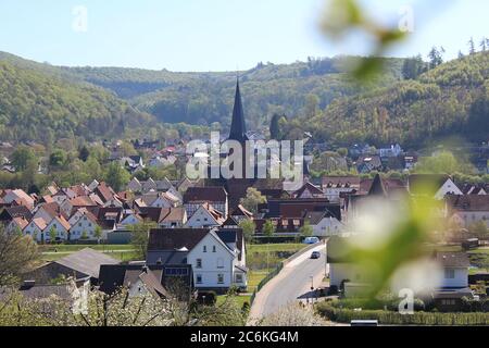 Small town view of Luegde,Germany in spring with church in center and blurry blossoms. Stock Photo