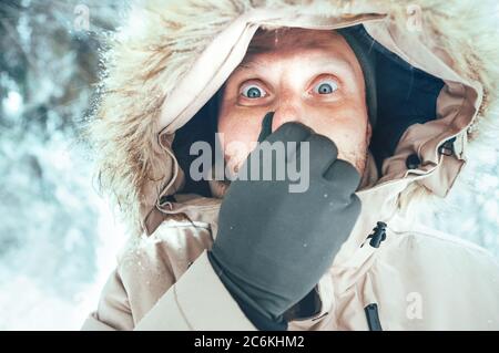 Funny man dressed in Warm Hooded Casual Parka Jacket Outerwear with frozen nose winter portrait. Health on winter time concept image.