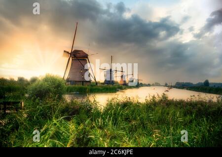 Beautiful Dutch windmills and landscape under dramatic sunset sky Stock Photo