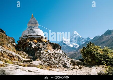 Buddhist Stupa - architectural and religious structure with Ama Dablam 6814m peak covered with snow and ice. Imja Khola valley in  Sagarmatha National Stock Photo