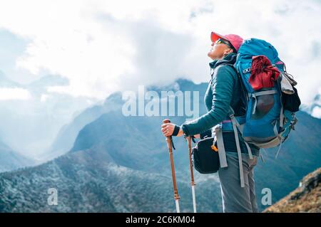 Young hiker backpacker female enjoying the valley and mountains view during high altitude Acclimatization walk. Everest Base Camp trekking route, Nepa Stock Photo