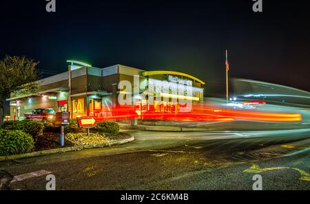 McDonald's Restaurant in Coos Bay, Oregon at night with car light streaks. Stock Photo