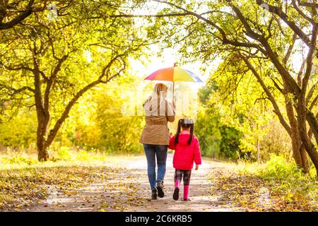 Young mother and her little daughter outdoors in colorful raincoats Stock Photo