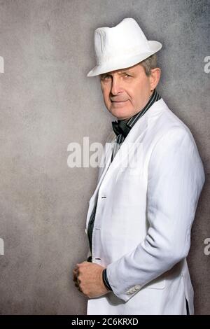 Attractive elderly man dressed in white with hat and elegant style Stock Photo