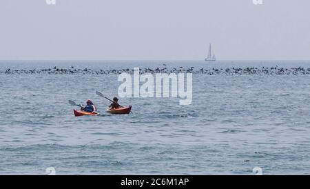 Toronto, Canada. 10th July, 2020. People paddle in Lake Ontario during a heat wave in Toronto, Canada, on July 10, 2020. The temperature in Toronto marked the ninth consecutive day of temperature over 30 degrees Celsius on Friday. Credit: Zou Zheng/Xinhua/Alamy Live News Stock Photo