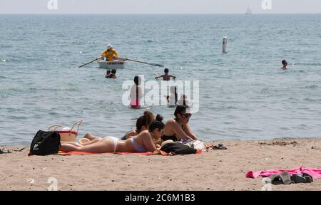 Toronto, Canada. 10th July, 2020. People enjoy leisure time on a beach of Lake Ontario during a heat wave in Toronto, Canada, on July 10, 2020. The temperature in Toronto marked the ninth consecutive day of temperature over 30 degrees Celsius on Friday. Credit: Zou Zheng/Xinhua/Alamy Live News Stock Photo