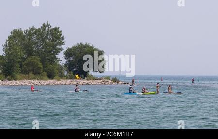 Toronto, Canada. 10th July, 2020. People paddle in Lake Ontario during a heat wave in Toronto, Canada, on July 10, 2020. The temperature in Toronto marked the ninth consecutive day of temperature over 30 degrees Celsius on Friday. Credit: Zou Zheng/Xinhua/Alamy Live News Stock Photo