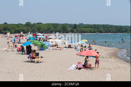 Toronto, Canada. 10th July, 2020. People enjoy leisure time on a beach of Lake Ontario during a heat wave in Toronto, Canada, on July 10, 2020. The temperature in Toronto marked the ninth consecutive day of temperature over 30 degrees Celsius on Friday. Credit: Zou Zheng/Xinhua/Alamy Live News Stock Photo