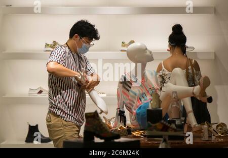 Toronto, Canada. 10th July, 2020. A shoe store employee wearing a face mask adjusts a mannequin at CF Toronto Eaton Center in Toronto, Canada, on July 10, 2020. The economy added 953,000 jobs in Canada, and the jobless rate fell to 12.3 percent in June, as businesses reopened after the COVID-19 shutdown, according to Statistics Canada Friday. Credit: Zou Zheng/Xinhua/Alamy Live News Stock Photo