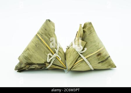 Closeup view of the zongzi, it is a traditional Chinese rice dish made of glutinous rice stuffed with different fillings and wrapped in reed leaves. Stock Photo