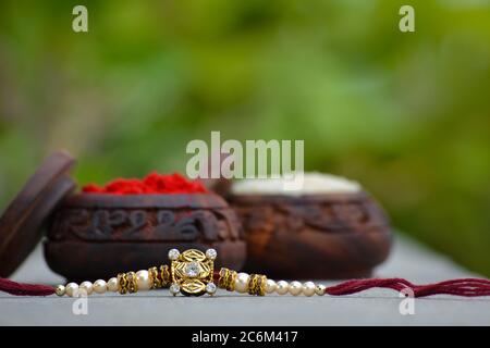 Raksha bandhan rakhi with rice grains and kumkum. A traditional indian wrist band which is a symbol of love between Brothers and Sisters Stock Photo