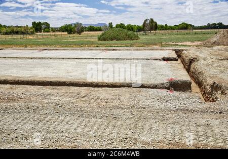Level building site pad with three foot deep footing trench for a new building Stock Photo