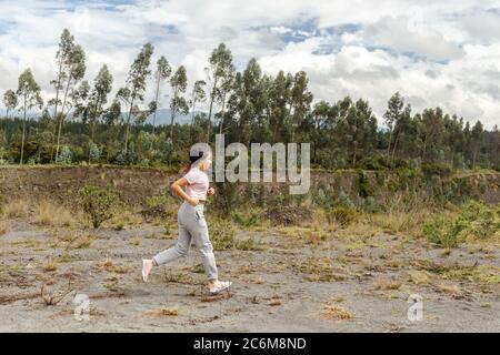 Pretty girl teenager runner in the forest between trees Stock Photo