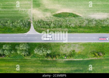 aerial top view of traffic on road through countryside and cultivated fields Stock Photo
