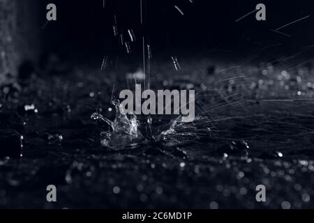 Water drop splashes on black background image Stock Photo