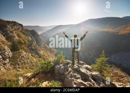 Man standing on the cliff. Conceptual scene. Mountain nature composition. Stock Photo