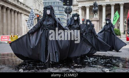 Black Brigade of Extinction Rebellion protest outside the Bank Of England to highlight the bailout of the big corporations. Stock Photo