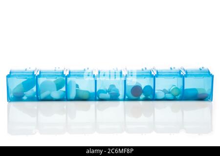 Pill organizer box storing doses of daily medicine on white background Stock Photo