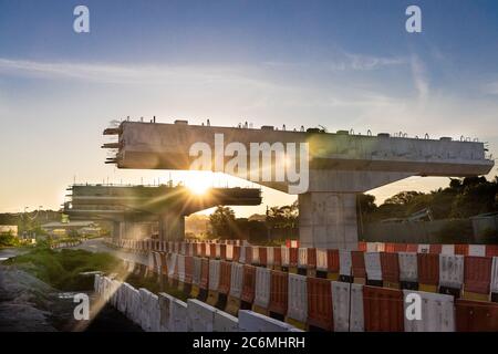 Silhouette with morning sun rays on highway overpass bridge infrastructure under construction in Malaysia Stock Photo