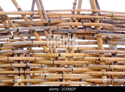 A traditional handmade bamboo fence made from slats and strips Stock Photo