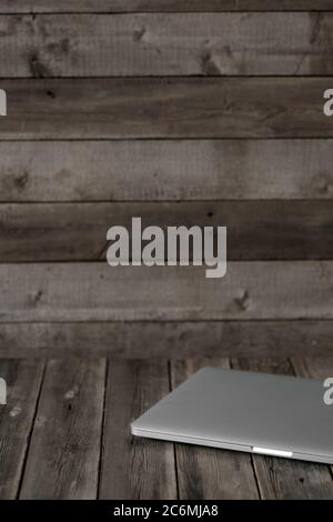 Mock up of blank laptop on the desk. Personal laptop computer on wood table over brick wall background. Stock Photo