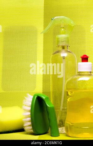 Set for cleaning various surfaces in the kitchen, bathroom and other areas. in yellow on the background . Concept of home cleaning services. Front view. Stock Photo