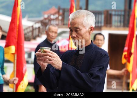 (200711) -- FUZHOU, July 11, 2020 (Xinhua) -- A villager demonstrates a funeral ritual for deceased carp in Puyuan Village, Puyuan Township, Zhouning County, southeast China's Fujian Province, July 4, 2020.  At the first glance, Puyuan Village appears no difference from other historical villages in China. But it's the carp fish in a local creek, known as the Carp Brook, that make the village special.     Puyuan village covers an area of 9.2 square kilometers and has a population of about 6,200. Originated from the Ziyun Mountain, several streams converge into the 3,000-meter-long Carp Brook, w Stock Photo