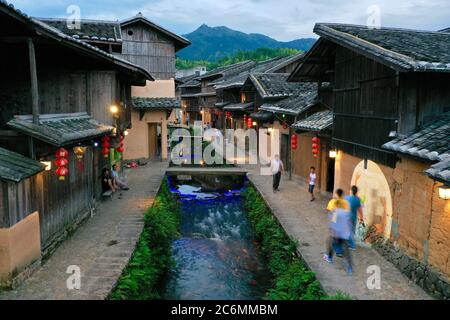 (200711) -- FUZHOU, July 11, 2020 (Xinhua) -- Photo taken with a drone shows villagers and tourists walking by the Carp Brook around sunset in Puyuan Village, Puyuan Township, Zhouning County, southeast China's Fujian Province, July 3, 2020.  At the first glance, Puyuan Village appears no difference from other historical villages in China. But it's the carp fish in a local creek, known as the Carp Brook, that make the village special.     Puyuan village covers an area of 9.2 square kilometers and has a population of about 6,200. Originated from the Ziyun Mountain, several streams converge into Stock Photo