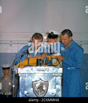 (18 Dec. 1965) --- Astronauts Frank Borman (left), Gemini-7 command pilot, and James A. Lovell Jr., pilot, take time out during their welcoming ceremonies aboard the aircraft carrier USS Wasp to autograph a life preserver. Stock Photo