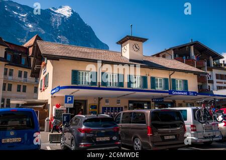 Grindelwald, Bernese Oberland Switzerland - July 30 2019 : Main railway station building on bright summer day with clear blue sky and famous Eiger nor Stock Photo