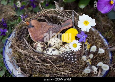 easter nest with bird, quail eggs and flowers as easter decoration Stock Photo