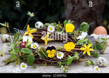 willow wreath with spring flowers and branches as easter decoration Stock Photo