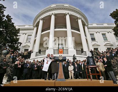 President George W. Bush holds up a University of Texas Longhorns jersey with head football coach Mack Brown, Tuesday, Feb. 14, 2006, during South Lawn ceremonies to honor the 2005 NCAA Football Champions. Stock Photo