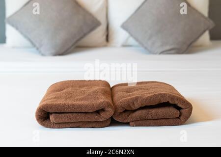 Brown towel on bed in guest room for hotel customer. Stock Photo