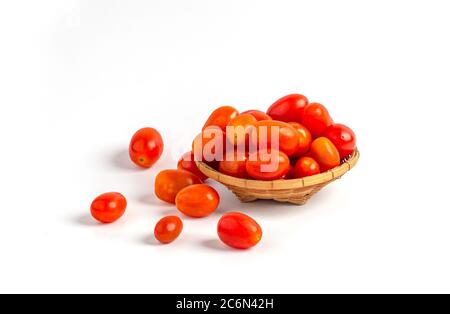 Red baby plum tomatoes in a basket isolated on white background. Stock Photo