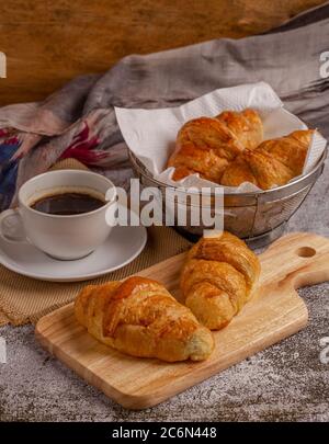 freshly baked croissants with black coffee on grey table for breakfast Stock Photo