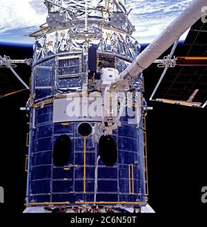 (11-21 Feb. 1997) --- Astronaut Mark C. Lee, standing on the end of the Remote Manipulator System (RMS), works at the data interface unit on the Hubble Space Telescope (HST), temporarily captured in the cargo bay of the Earth-orbiting the Space Shuttle Discovery. Stock Photo