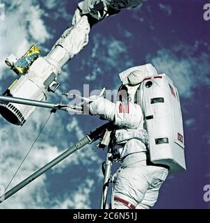 (11-21 Feb. 1997) --- Astronauts Mark C. Lee, STS-82 payload commander, (bottom), and Steven L. Smith, mission specialist, handle Hubble Space Telescope (HST) replacement parts during Extravehicular Activity (EVA) on Flight Day 4. The two were participating in the first of five eventual days of EVA to service the giant orbital observatory. Smith is standing on the end of the Remote Manipulator System (RMS) arm, which was controlled by astronaut Steven A. Hawley inside the Space Shuttle Discovery's crew cabin. Stock Photo