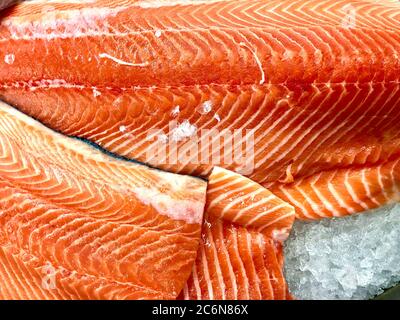 Freshly cut filets of delicious salmon on ice at a fish market Stock Photo