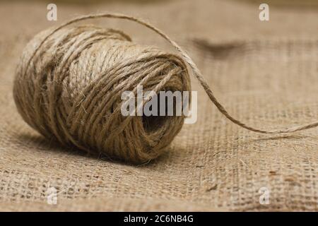 The rope is twisted in a coil. Hank of twine on sacking Stock Photo
